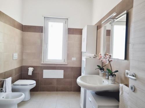 La salle de bains est pourvue de toilettes, d'un lavabo et d'un miroir. dans l'établissement La GreenHouse - Isola di Capo Rizzuto, à Isola di Capo Rizzuto