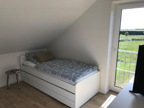 a small bed in a room with a window at Ferienhaus Wiesenkate in Hohwacht