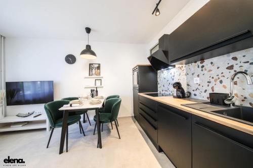 eine Küche mit einem Tisch und grünen Stühlen und einer Spüle in der Unterkunft Studio apartment Elena in Rijeka