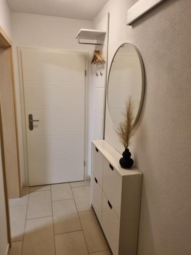 a bathroom with a mirror and a dresser and a door at Appartment im Untergeschoss in Freilassing