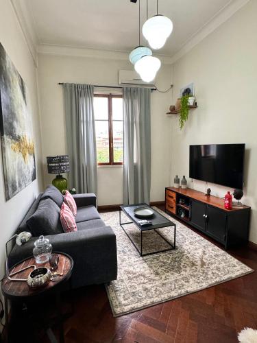 uma sala de estar com um sofá e uma televisão de ecrã plano em Buenos Aires, Recoleta, Capital Federal em Buenos Aires