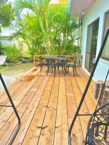 a wooden deck with a table and benches on it at 広い庭付きBBQ可,残波ビーチまで車で5分,最大人数11名 Ns garden in Jima