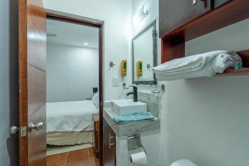 a bathroom with a sink and a mirror and a bed at New Puerto Vallarta Retreat with Private Terrace in Puerto Vallarta