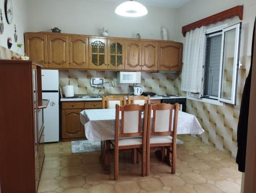 a kitchen with wooden cabinets and a table and chairs at Fotinishouse in Stavrochórion