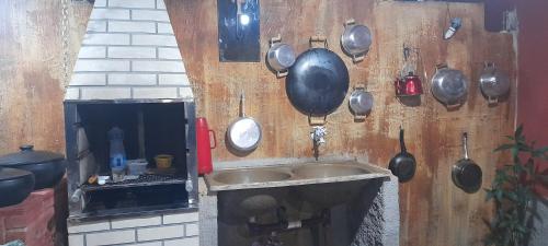 uma cozinha com panelas e frigideiras penduradas numa parede em Casa girassol em Nova Friburgo