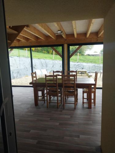 une salle à manger avec une table et des chaises en bois dans l'établissement Gîte en lisière de forêt andaine, à Perrou