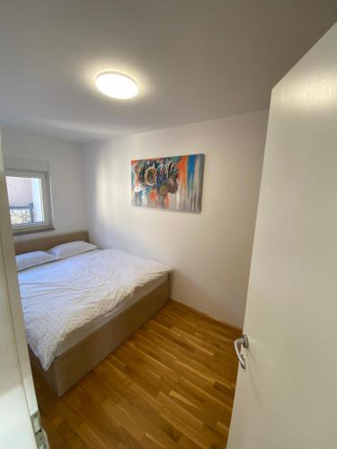 um quarto com uma cama e um quadro na parede em Tessitura Murter apartman em Murter