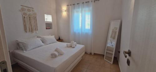 a white bedroom with a bed with white towels on it at Aloni in Áno Meriá
