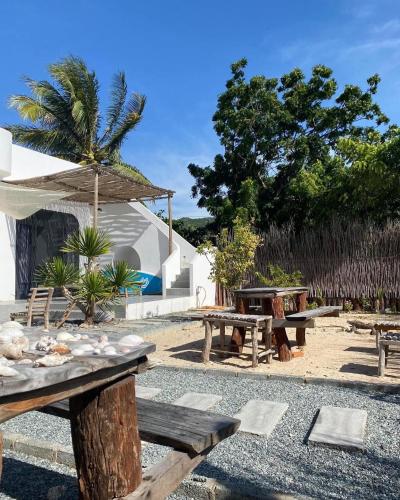a group of picnic tables and an umbrella at My Hoa Oceanfront Home in Ấp Mỹ Hải