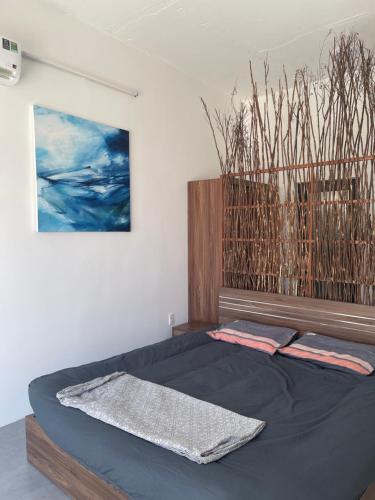 ein Schlafzimmer mit einem Bett mit einer schwarzen Tagesdecke in der Unterkunft My Hoa Oceanfront Home in Ấp Mỹ Hải