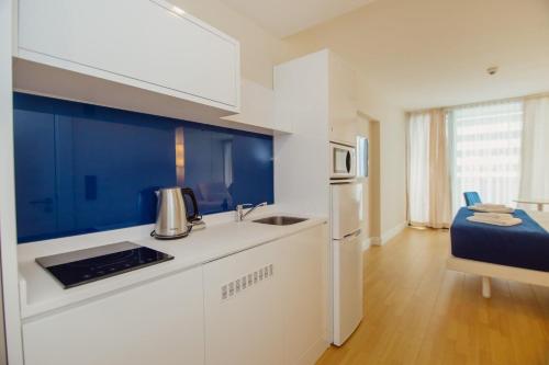 a kitchen with a sink and a refrigerator at Orbi City with Sea View in Batumi