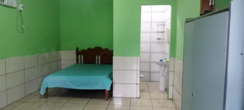 Hostel e Pousada Israel في ريو برانكو: غرفة خضراء مع سرير في الحمام