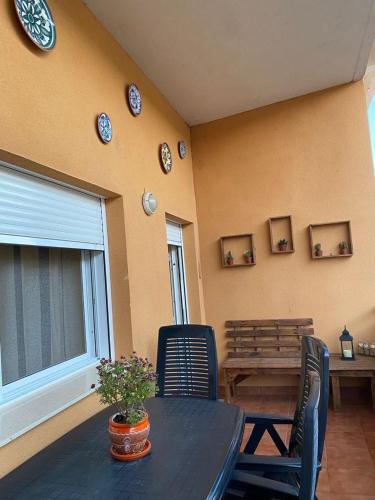 une salle à manger avec une table, des chaises et des horloges murales dans l'établissement Apartament Els Flamencs, à Els Muntells