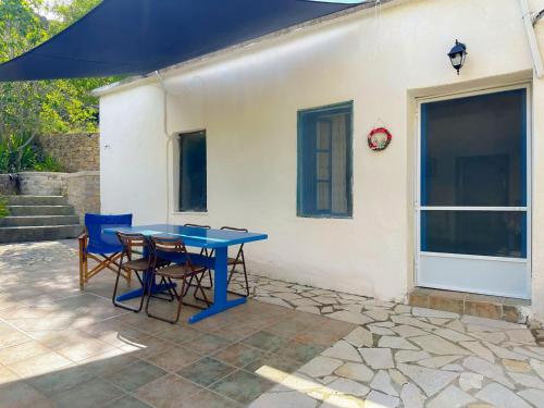 a blue table and chairs in front of a house at To Provetzino in Viarádhika