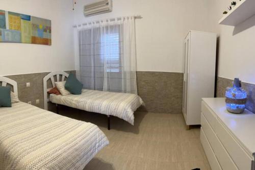 a small bedroom with two beds and a refrigerator at Apartamento Casa el Canario in Costa Teguise