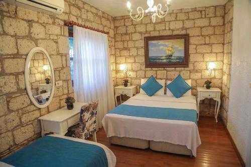 a hotel room with two beds and a mirror at Alaçatı Kavalalı Otel in Alaçatı