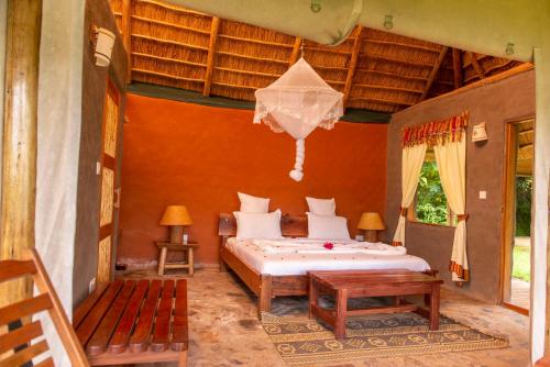 Sharp Island Gorilla Lodge, Lake Bunyonyi في Kashasha: غرفة نوم بسرير في غرفة