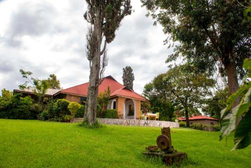 a house with a fire hydrant in the grass at Sharp Island Gorilla Lodge, Lake Bunyonyi in Kashasha