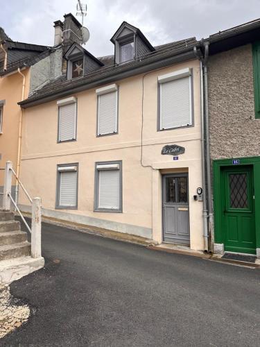 a building with a green door on a street at Studio cocooning à Cauterets 3 personnes in Cauterets