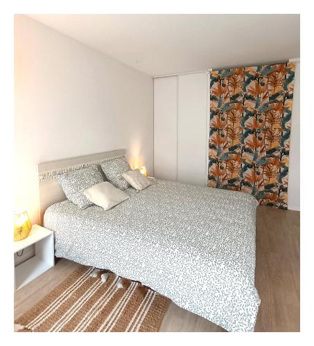 - une chambre avec un grand lit et un couvre-lit blanc dans l'établissement Studio Chemin Bleu, à Lourdes