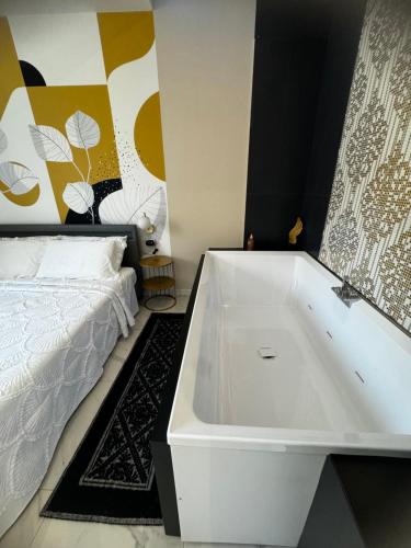 a white bath tub in a bedroom with a bed at Cagliari Love Suite in Cagliari