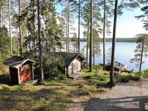 a cabin in the woods next to a lake at Lomamökki Kuhmo, Tervatörmä in Kuhmo