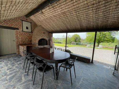 a dining room with a table and chairs and a fireplace at Gite Pays de Herve - Emeraude in Battice