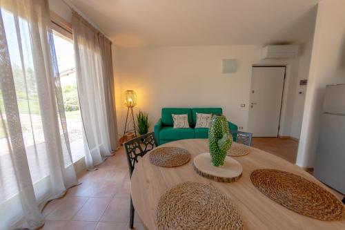 une salle à manger avec une table et un canapé vert dans l'établissement Vistaverde Harmony Apartments, à Cavaion Veronese