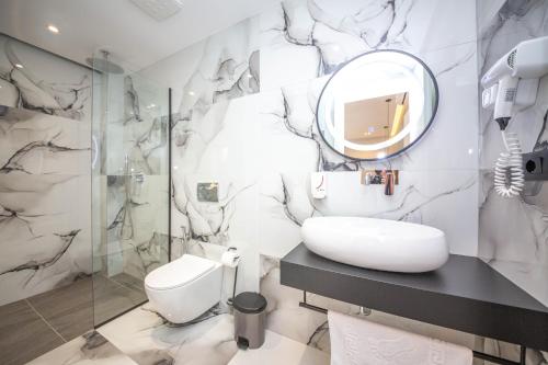 a bathroom with a sink and a mirror at Absolute Hotel Ksamil in Ksamil