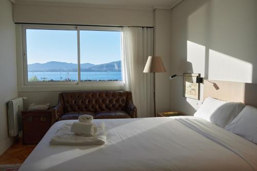 a hotel room with a bed and a couch and a window at Exclusivo piso puerto de Vigo in Vigo