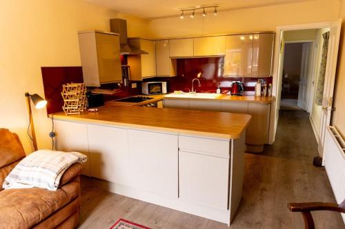 a kitchen with white cabinets and a wooden counter top at The Bothy in Dundee