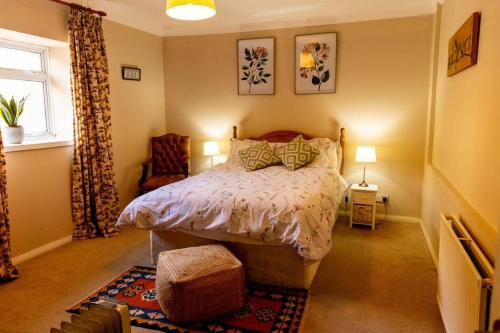 a bedroom with a bed and a chair and a window at The Bothy in Dundee