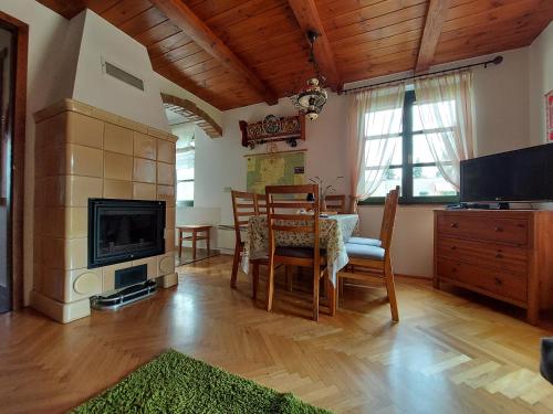 ein Wohnzimmer mit einem Tisch und einem TV sowie ein Esszimmer in der Unterkunft Titi Family Apartman in Bük