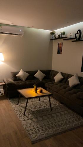 sala de estar con sofá y mesa de centro en غرفه وصاله انيقه بالعقيق, en Riad