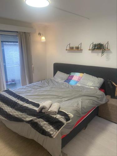 a bedroom with a bed with a blanket and a window at Appartement in hartje lier in Lier