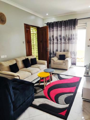 a living room with a couch and a table and a rug at VaanaKabod in Kampala