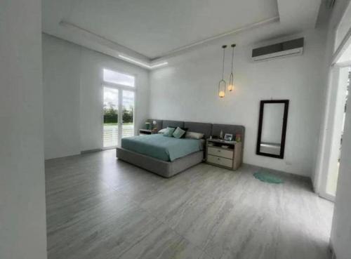 Habitación blanca con cama y espejo en Alojamiento en Samborondon, en Guayaquil