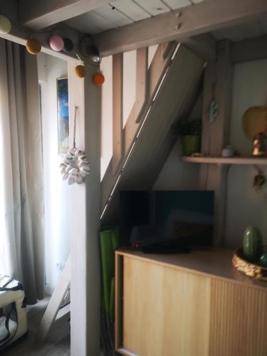 - un salon avec une télévision et un escalier dans l'établissement T2 résidence piscine et direct plage, à Saint-Cyprien