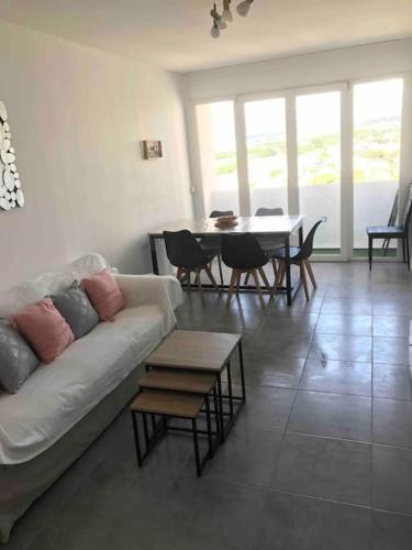 un salon avec un canapé et une table avec des chaises dans l'établissement T4 près du stade vélodrome et des plages, à Marseille