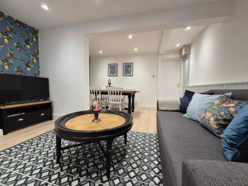a living room with a couch and a table at Dog-Friendly Basement Apartment with Garden - Southsea, Portsmouth #26a in Portsmouth
