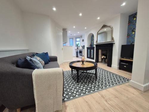 a living room with a couch and a table at Dog-Friendly Basement Apartment with Garden - Southsea, Portsmouth #26a in Portsmouth