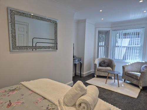 a bedroom with a bed and a chair and a mirror at Dog-Friendly Basement Apartment with Garden - Southsea, Portsmouth #26a in Portsmouth