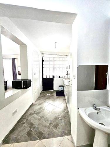 La salle de bains blanche est pourvue d'un lavabo et de toilettes. dans l'établissement Nyahururu 1 BR Apartment, à Nyahururu
