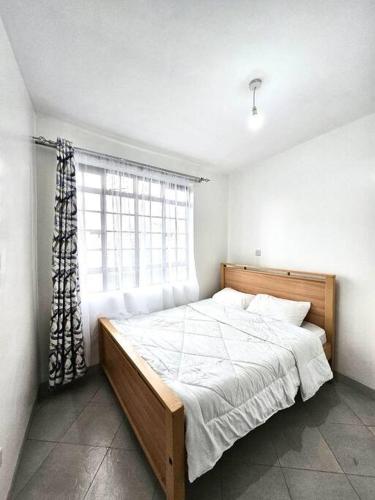 - une chambre avec un grand lit et une fenêtre dans l'établissement Nyahururu 1 BR Apartment, à Nyahururu