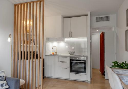 una cucina con armadietti bianchi e piano cottura di Studio lumineux à 2 mn à pied de la plage a Cannes