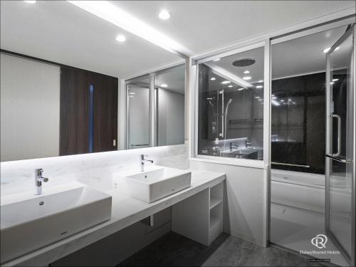 łazienka z 2 umywalkami i prysznicem w obiekcie Daiwa Roynet Hotel Aomori w mieście Aomori