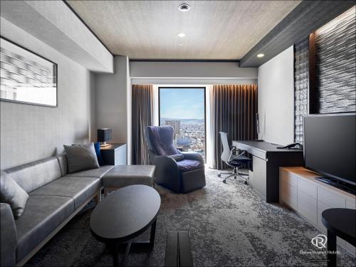 a living room with a couch and a television at Daiwa Roynet Hotel Aomori in Aomori