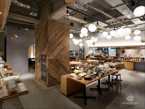 a restaurant with a table with food on it at Daiwa Roynet Hotel Aomori in Aomori