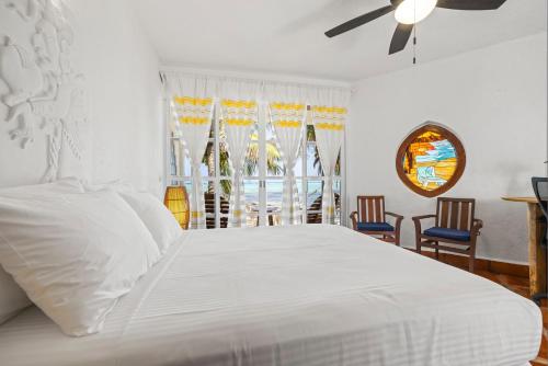 a bedroom with a white bed and a window at Casa Cenote Hotel in Tankah
