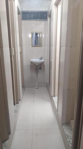Baño blanco con lavabo y espejo en Repouso do corcovado hostel, en Río de Janeiro